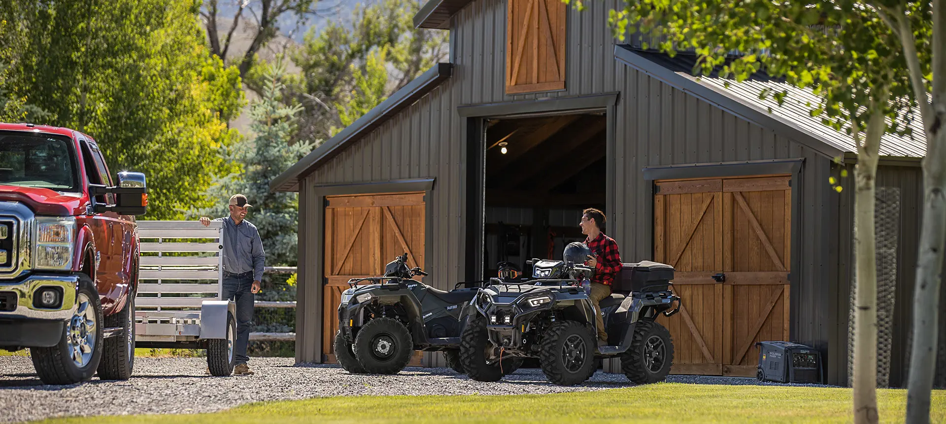Vue extérieure d’une grange avec deux véhicules Sportsman