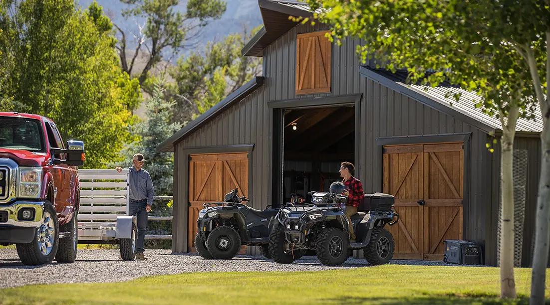 Vue extérieure d’une grange avec deux véhicules Sportsman
