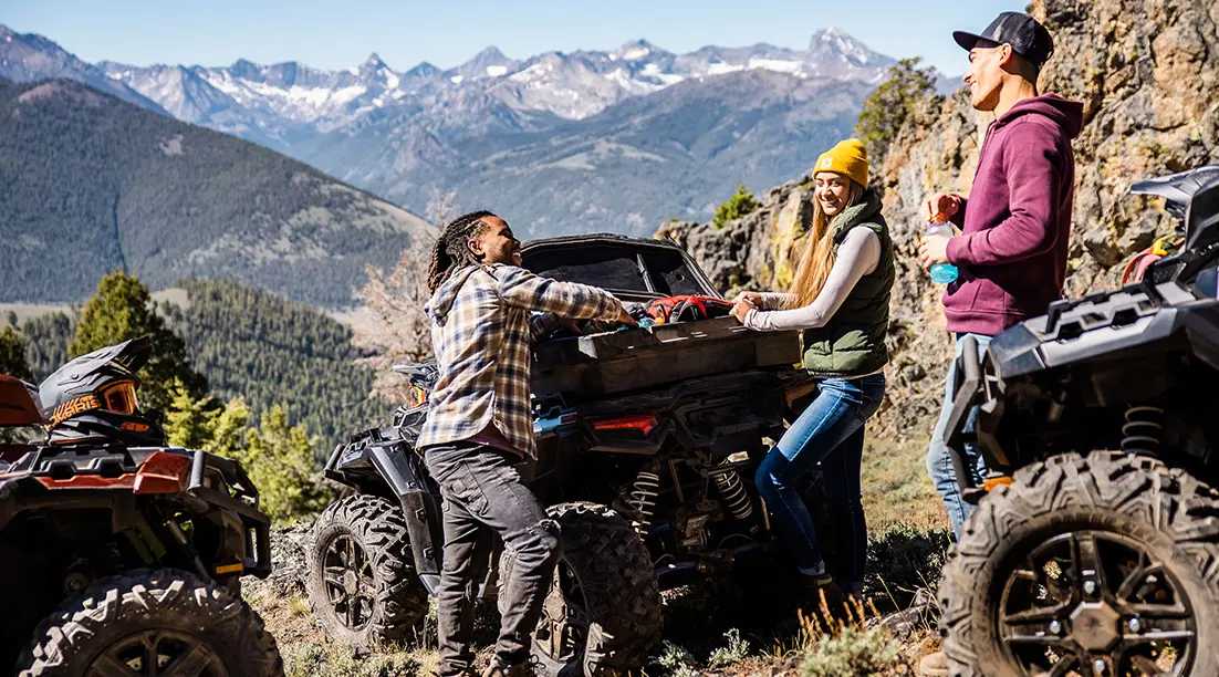 Trois amis se détendant sur une montagne à côté de leurs VTT