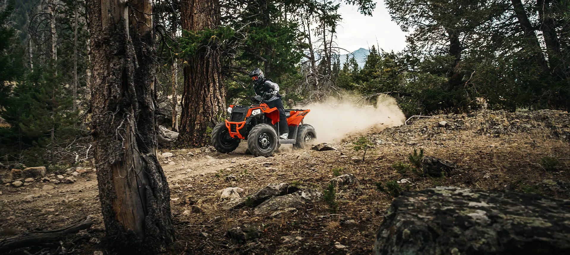 Man speeding down a forest trail on his Polaris Scrambler 850
