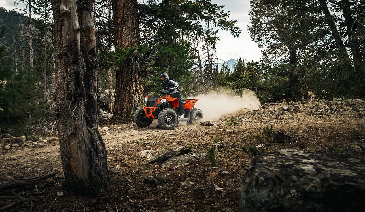 Man speeding down a forest trail on his Polaris Scrambler 850