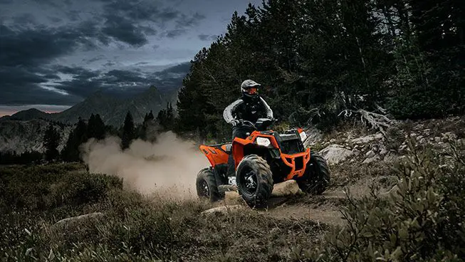 Rider climbing a steep hill with his Polaris Scrambler 850