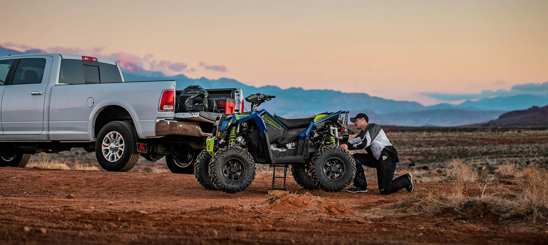 man adjusting the rear-end of his Scrambler XP 1000 S atv
