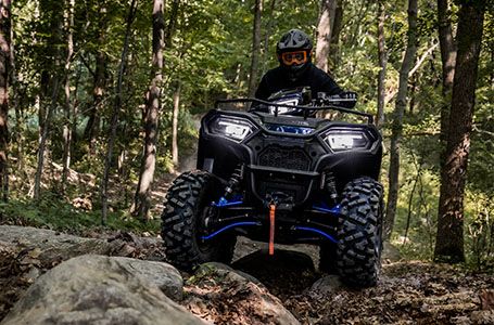 Man riding his Sportsman 570 through the forest
