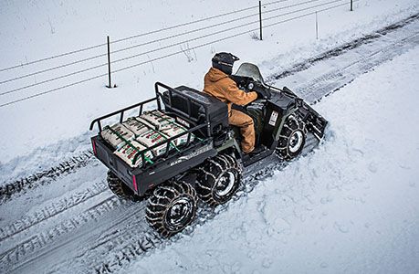 Man plowing snow easily with a plow on his polaris sportsman 6x6 570 