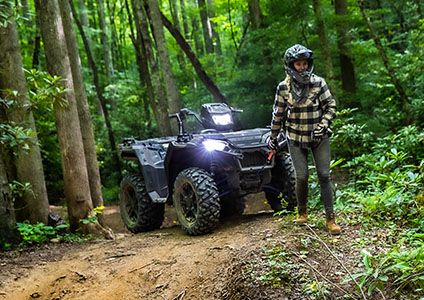 femme tirant le câble du treuil fixé à son polaris sportsman 850