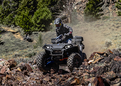 sportsman 850 with front and rear brushguard cruising down a rocky trail