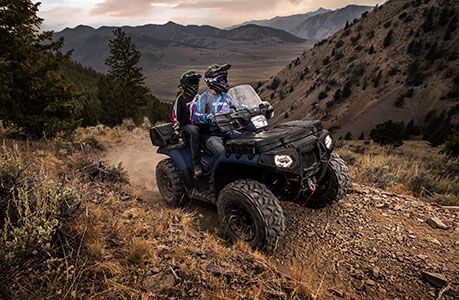 2 riders safely climbing a hill on their polaris sportsman touring 850