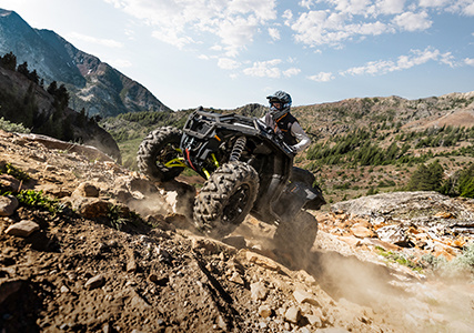 man speeding uphill to showcase the stronger transmission on his sportsman xp 1000 S