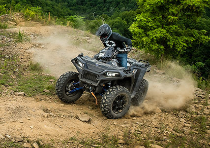 man riding up a hillside with his ride command equipped sportsman xp 1000