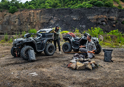 man and woman building a fire near their accessorized sportsman xp 1000s