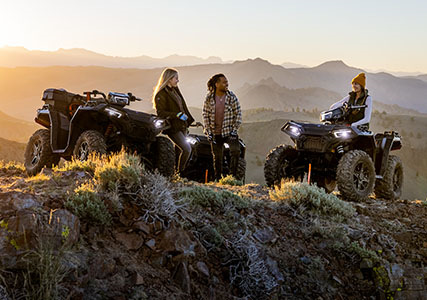 3 people relaxing after a ride on their sportsman xp 1000s