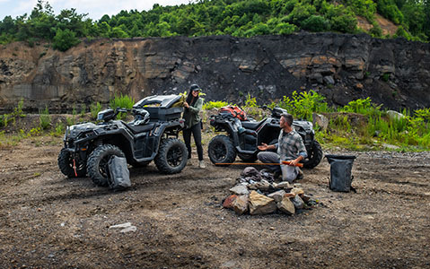 woman unloading gear from weather proof cargo on her sportsman xp 1000 with ride command