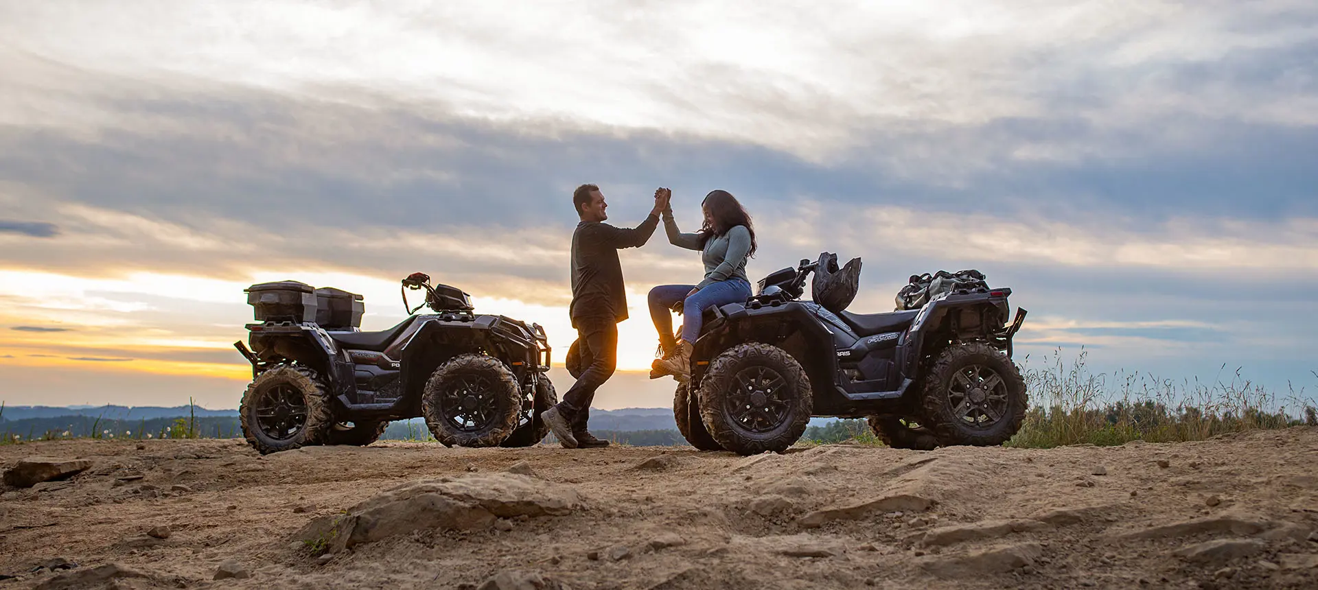 un hombre y una mujer se felicitan con las manos después de un gran paseo con sus polaris sportsman xp 1000.