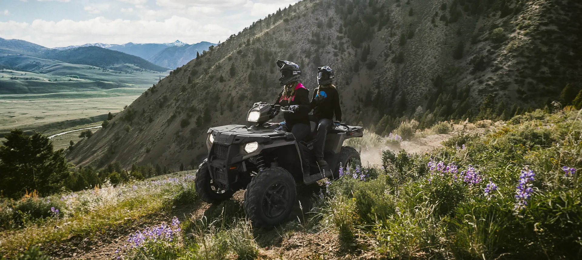 couple à bord d’un vtt sportsman touring dans une prairie
