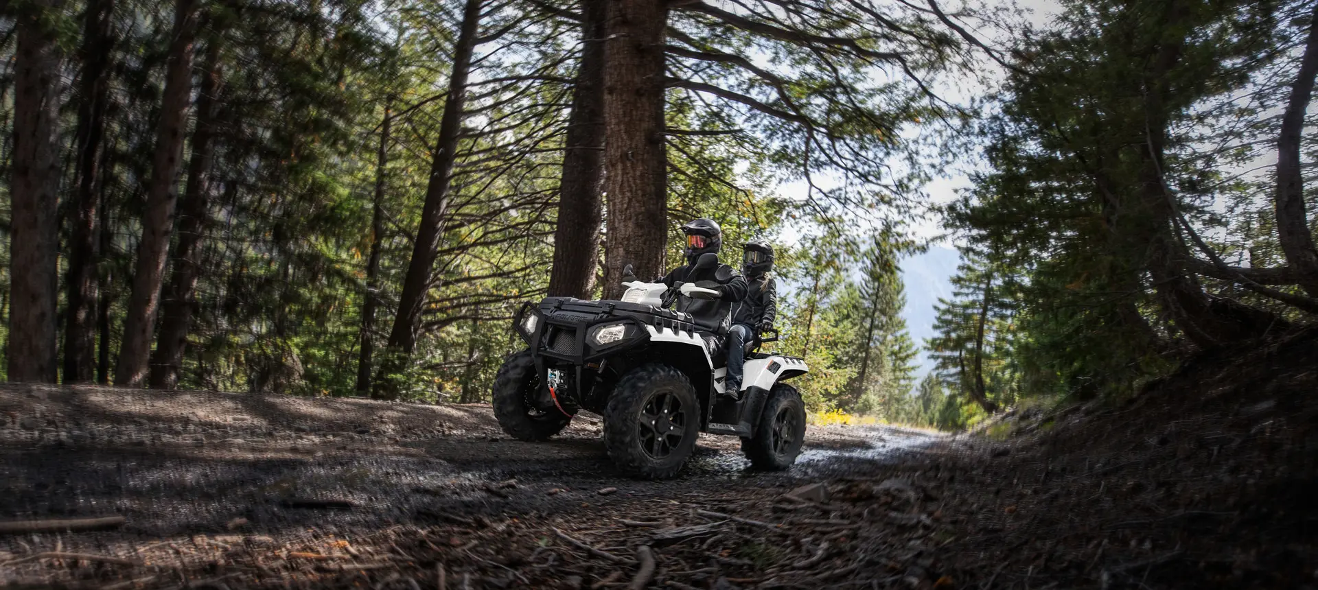 couple faisant du tout-terrain dans une forêt dans un vtt sportsman