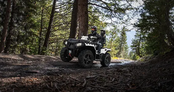 couple faisant du tout-terrain dans une forêt dans un vtt sportsman