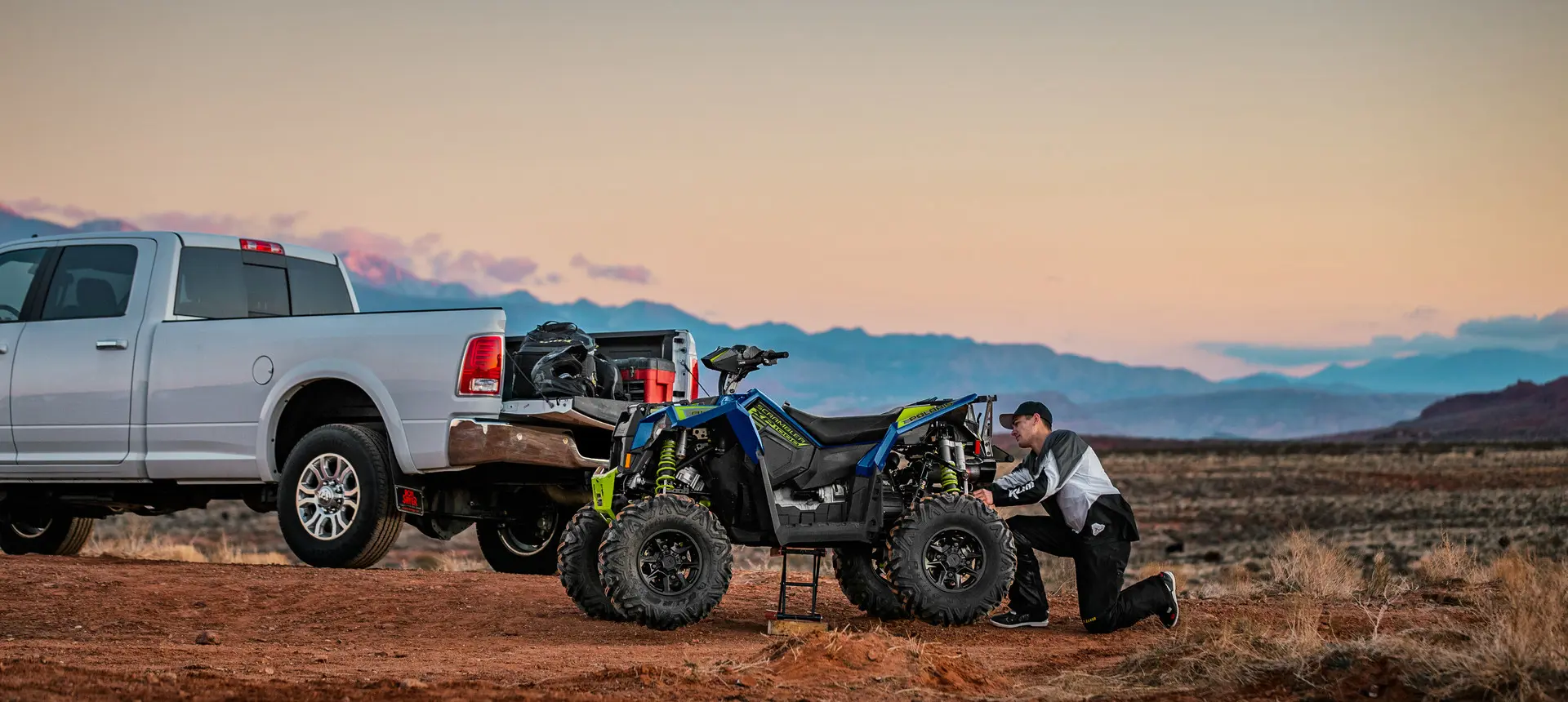 man adjusting the rear end on his polaris scrambler xp 1000 s atv