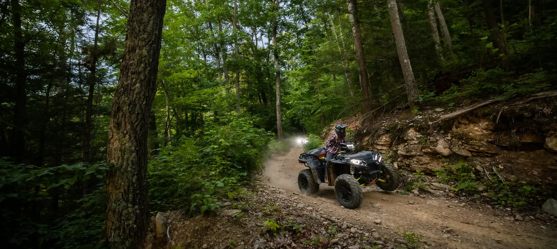 woman riding a sportsman xp 1000 s on a forest trail