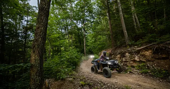 woman riding a sportsman xp 1000 s on a forest trail