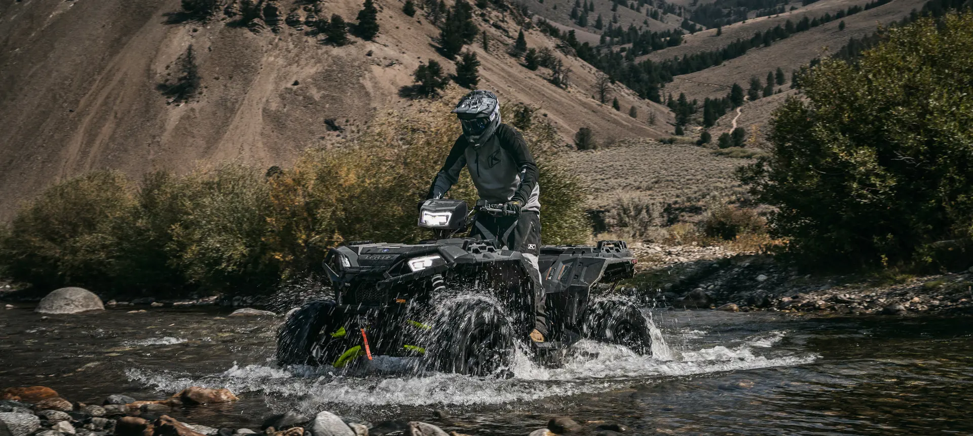 sportsman xp 1000 s atv driving through a riverbed