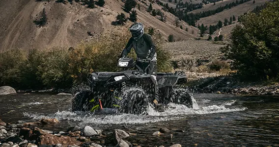 sportsman xp 1000 s atv driving through a riverbed
