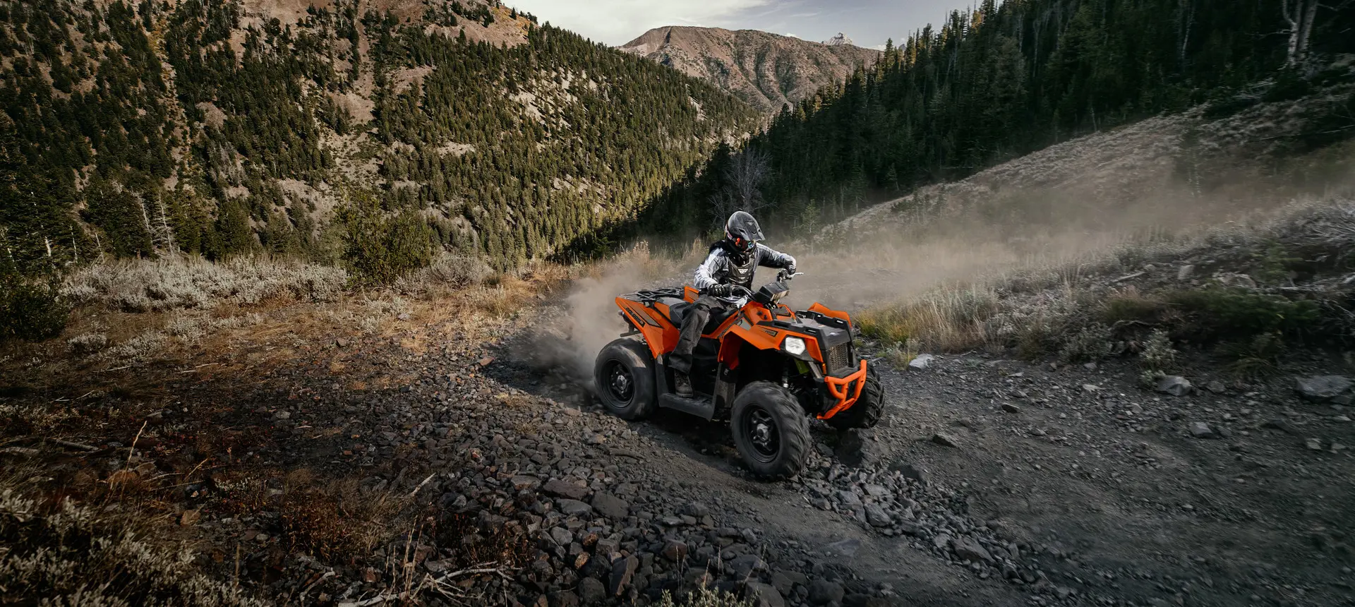 rider on a scrambler 850 atv traversing rocky terrain