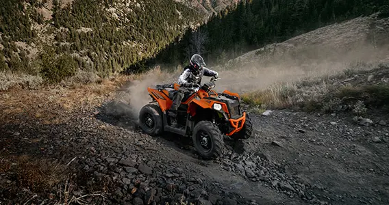 rider on a scrambler 850 atv traversing rocky terrain