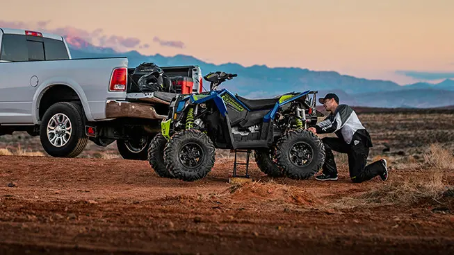 man adjusting the suspension on his radar blue scrambler xp 1000 s atv