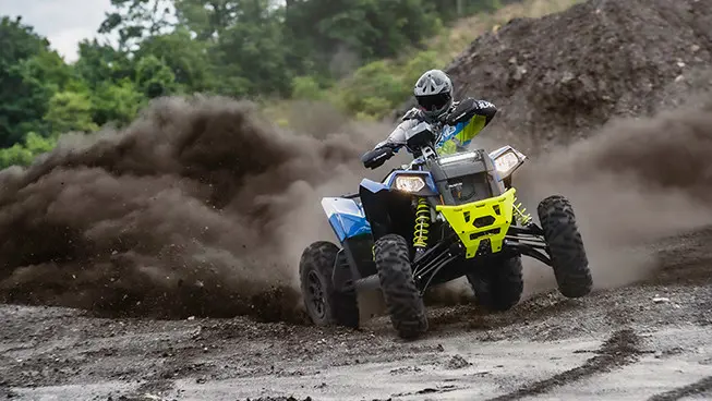 polaris scrambler xp 1000 s atv in radar blue tearing up a trail