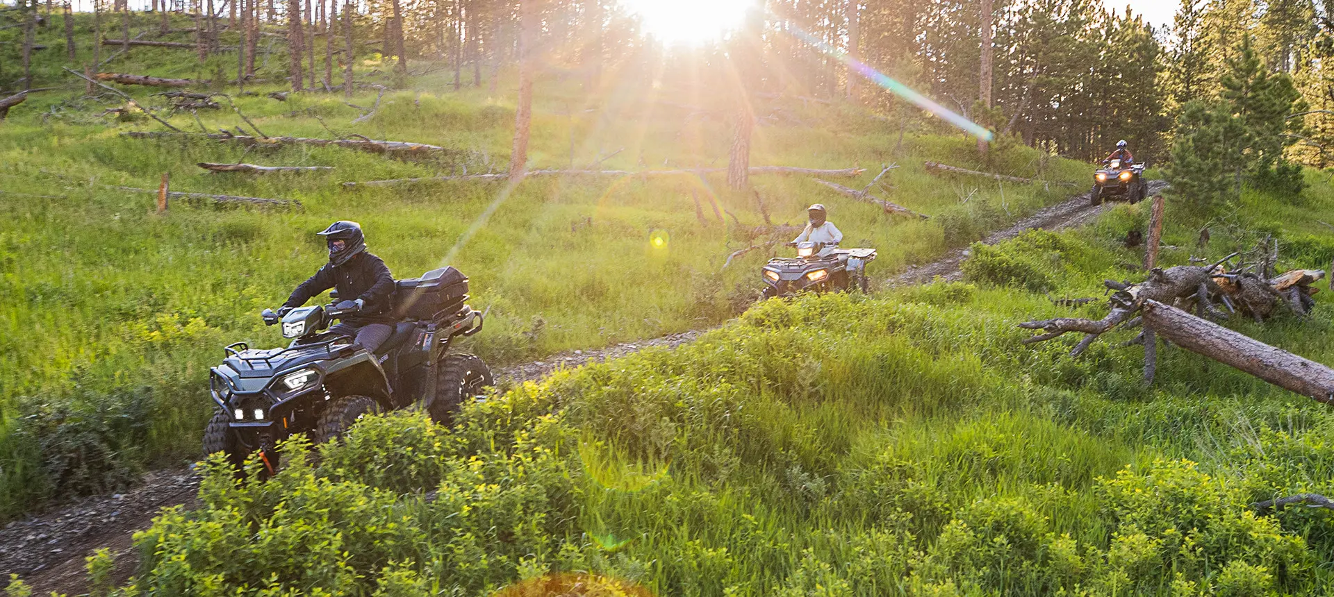 3 polaris sportsman 570 atvs cruising on a trail