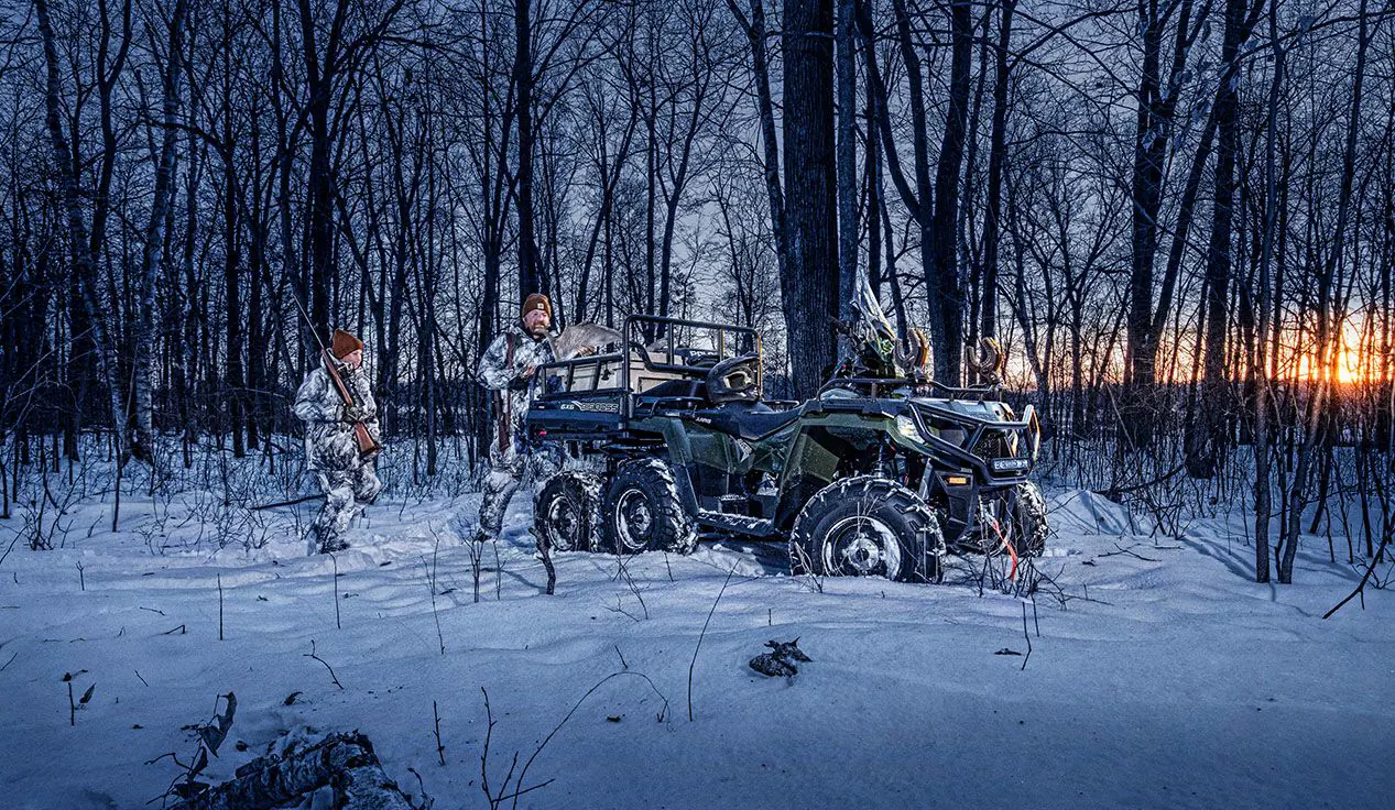 Cazadores cargando equipo en la caja trasera de su polaris sportsman 6x6 570