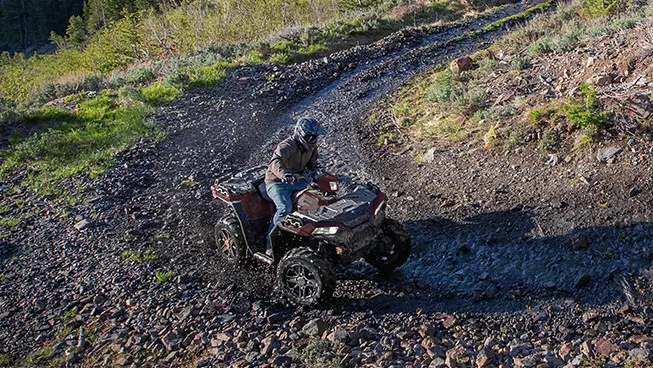 conducteur dans un vtt sportsman 850 lançant de la boue dans un coin