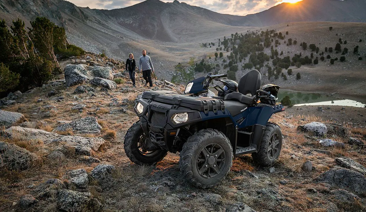 2 personnes marchant vers leur polaris sportsman touring 850