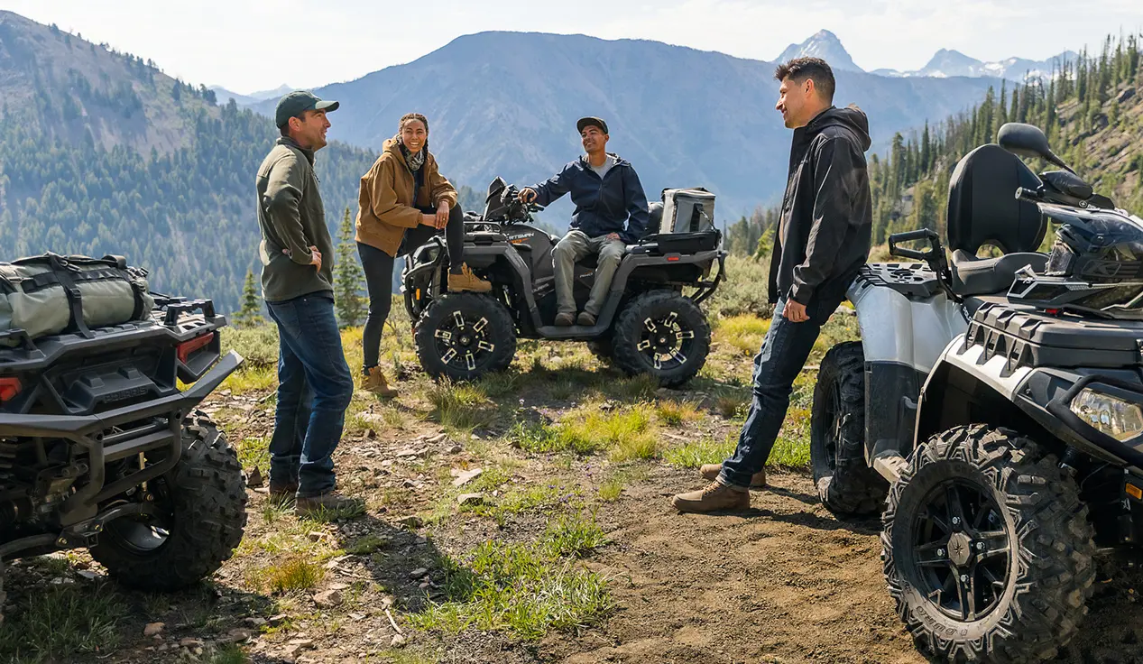 friends relaxing after a ride on their sportsman atvs