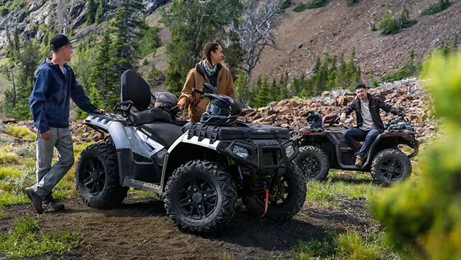 couple relaxing after a ride on their Sportsman Touring XP 1000 trail atv