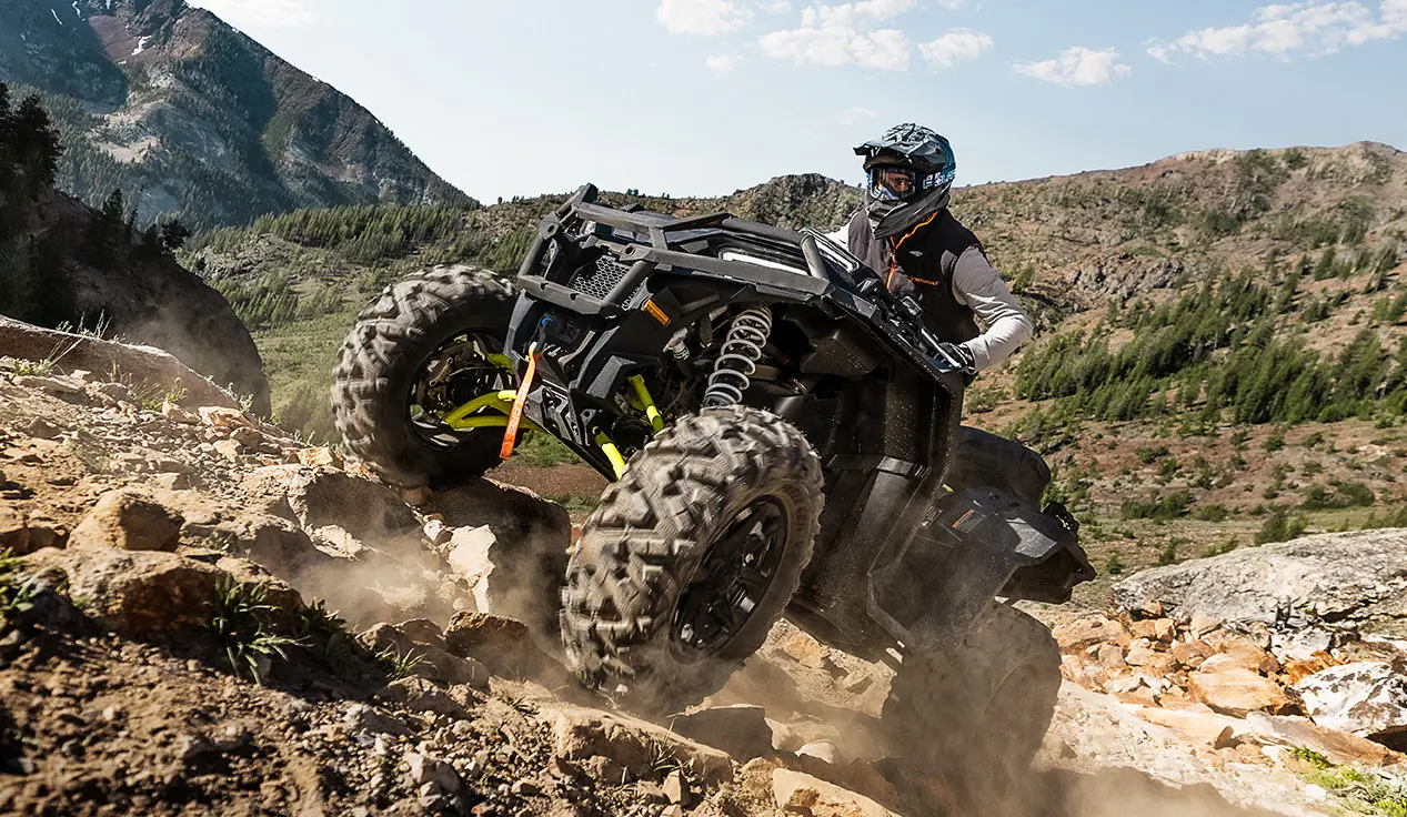 vtt sportsman xp 1000 s super graphite grimpant une colline rocheuse