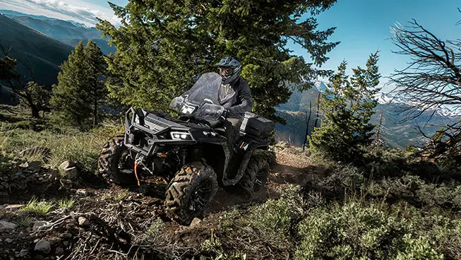 conductor en un atv sportsman xp 1000 en un sendero forestal