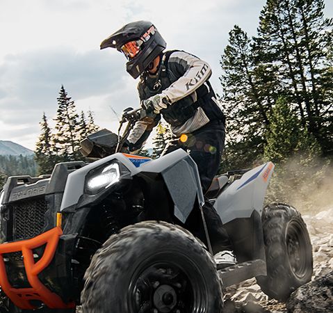 A rider on a 2025 Polaris Scrambler 850 sport ATV traversing rocky terrain.