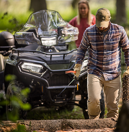 A man walking with chain and the 3500 ln Polaris HD winch of a 2025 Polaris Sportsman 6x6 570 2-up ATV.
