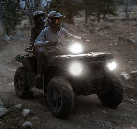 2 riders on a 2025 Polaris Sportsman Touring 850 ATV with new LED steerable pod and headlights. 