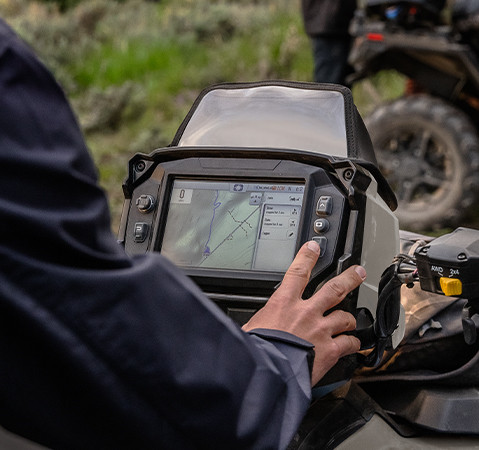 Close-up of the RIDE COMMAND touch screen GPS navigation system with Group Ride mounted on the handlebar of the 2025 Polaris Sportsman XP 1000 quad bike.