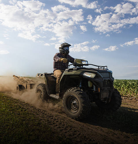A rider pulling a trailer with the strong 2026 Polaris Sportsman 4-wheeler.