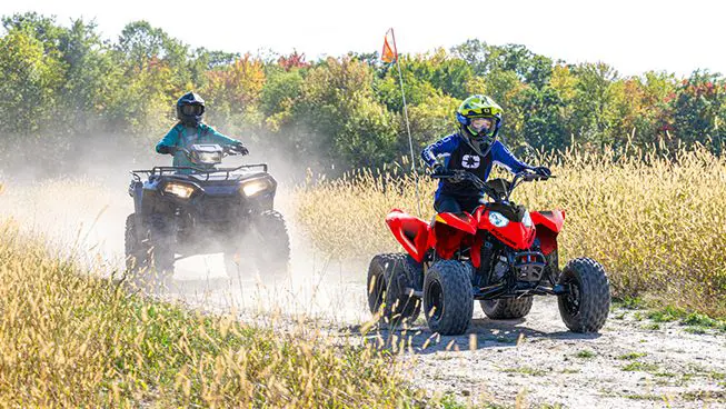 A girl having fun on her 2026 Polaris Outlaw 110 EFI youth ATV.