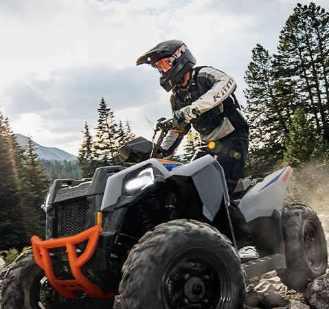 Rider showcasing the wider floorboards and a narrower stance at the knee on the 2026 Polaris Scrambler 850 sport ATV. 