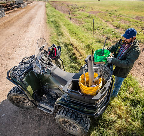 Fermier utilisant la rallonge de porte-bagages accessoire pour le support de cargaison de son Polaris Sportsman 450 2026 à quatre roues.