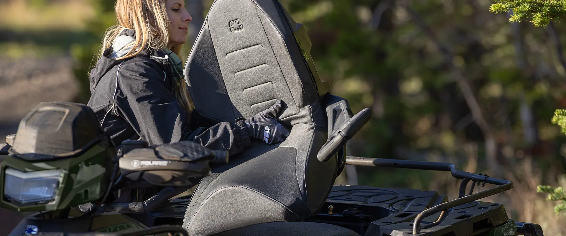 A woman installing the passenger seat on a 2026 Polaris Sportsman Touring 570 2-up ATV.