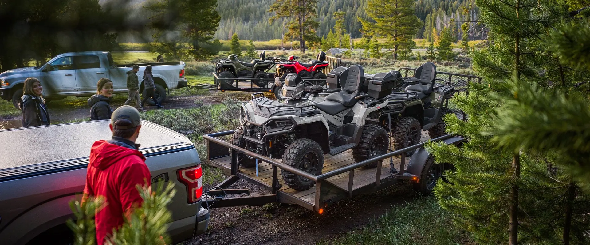 4 2026 Polaris Sportsman Touring 570 2-up ATVs on trailers being unloaded.