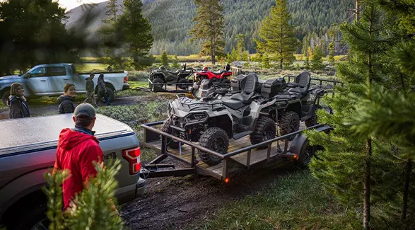 4 2026 Polaris Sportsman Touring 570 2-up ATVs on trailers being unloaded.