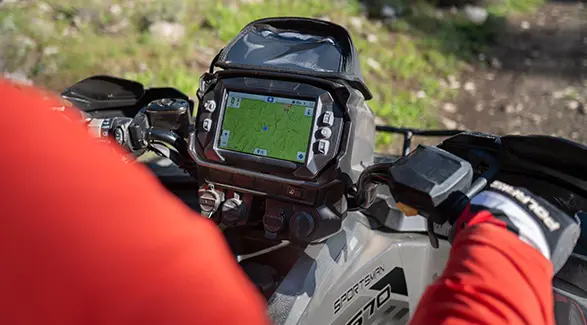 Over-the-shoulder view of a the RIDE COMMAND screen on the handlebars of a 2026 Polaris Sportsman Touring 570 2-up ATV.